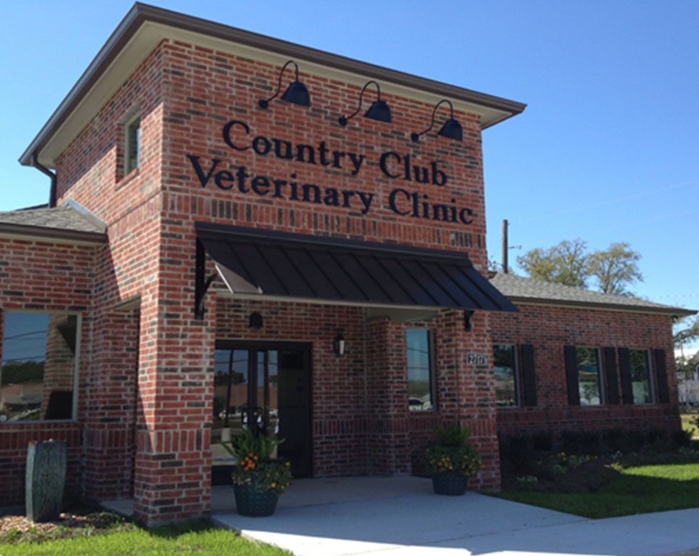 Brick veterinary clinic building with a sign reading "Country Club Veterinary Clinic."